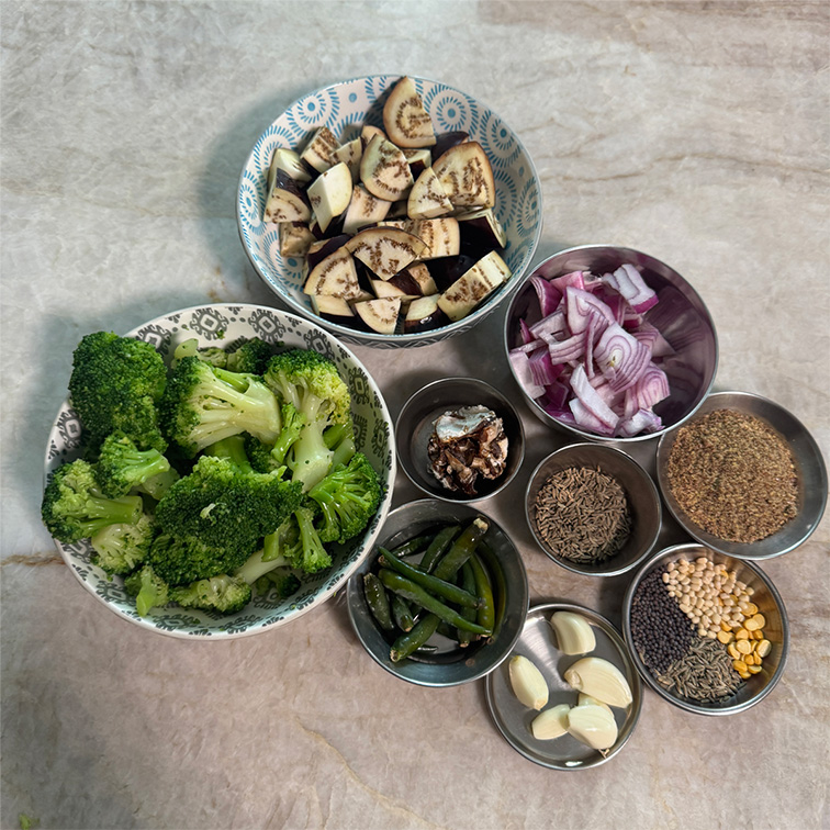 Fresh ingredients for homemade broccoli eggplant chutney arranged on a wooden table