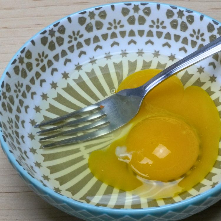 Fresh egg yolks in a clear bowl ready for making spicy omelette
