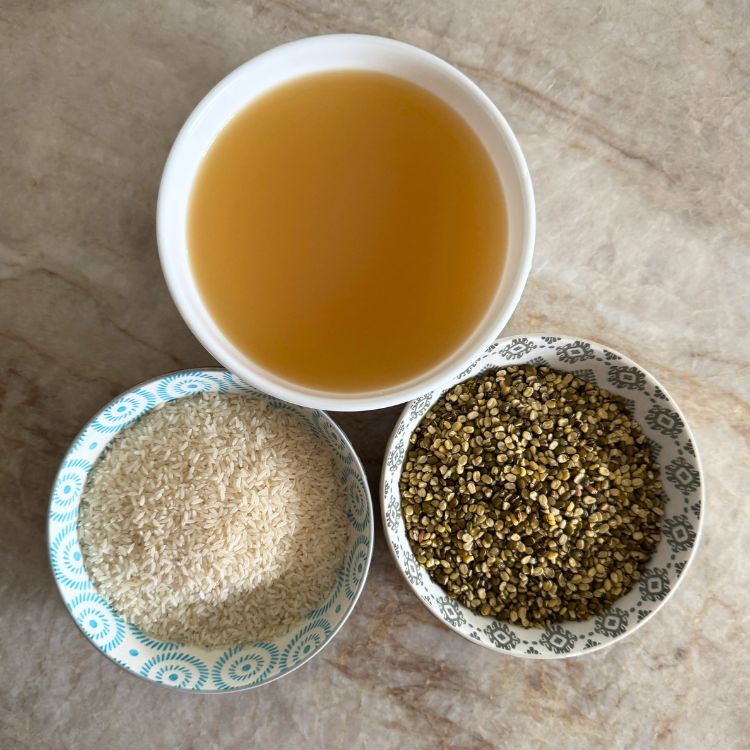 White rice, split green moong dal, and chicken broth in separate cups, ready to make high-protein rice.