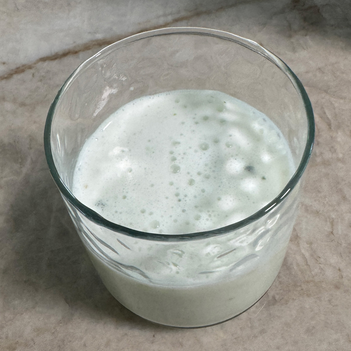 A glass of chilled homemade buttermilk, garnished with optional roasted cumin powder, ready to enjoy as a refreshing and healthy drink.