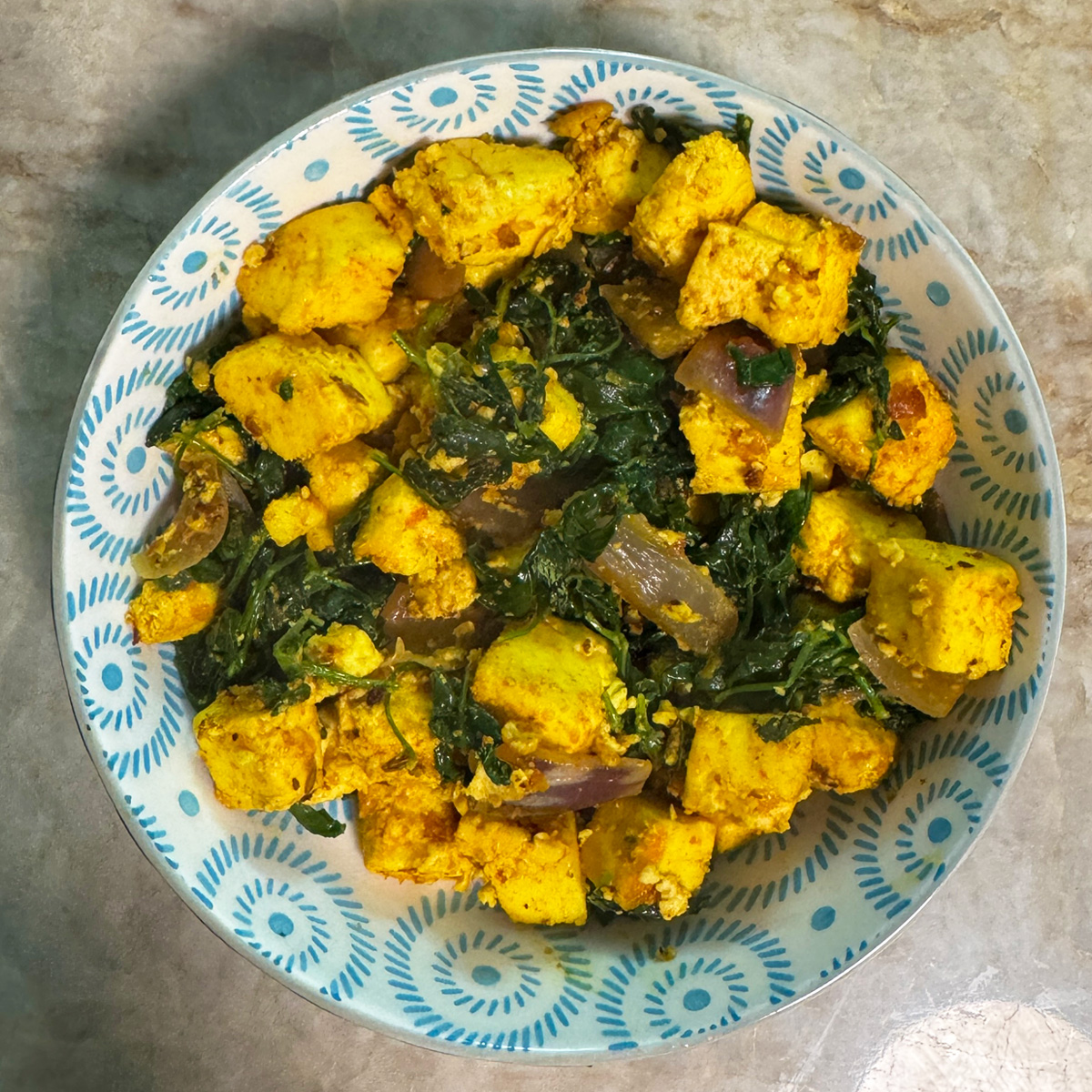 A serving of hot Methi Paneer Stir Fry in a bowl, garnished and ready to be enjoyed, showcasing the finished dish.
