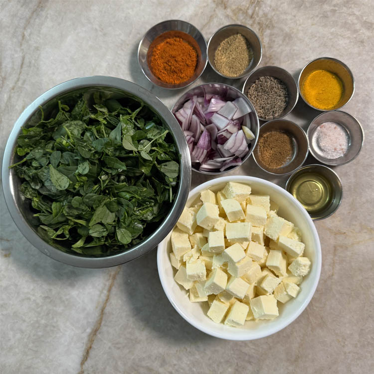 Bowls of paneer, methi leaves, onions, and spices laid out on a table, ready for a delicious Methi Paneer Stir Fry.