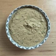 Overhead view of traditional South Indian peanut chutney in a ceramic bowl, highlighting its creamy texture and vibrant color