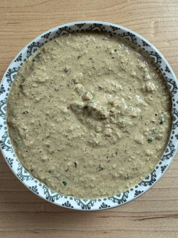 Overhead view of traditional South Indian peanut chutney in a ceramic bowl, highlighting its creamy texture and vibrant color