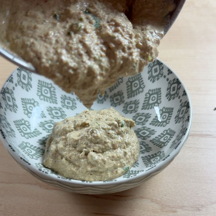 Smooth peanut chutney being poured from blender into a serving bowl, showcasing texture and consistency