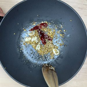 Garlic cloves, red chilies, and sesame seeds added to the hot spice tempering mix