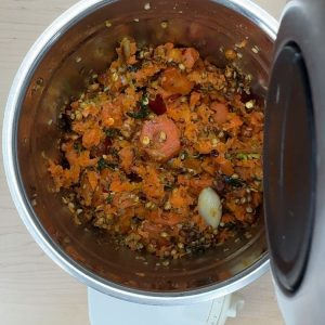 Adding water to the cooked mixture in a blender for a smooth chutney consistency