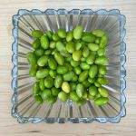 Boiled edamame served in a bowl on a wooden table