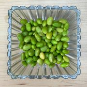 Boiled edamame served in a bowl on a wooden table