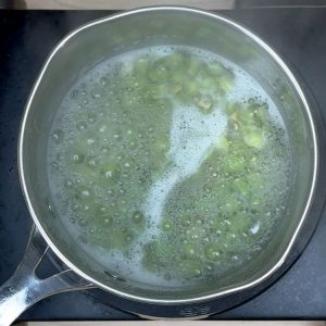 Edamame pods boiling in a pot of water