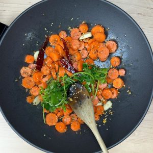 Chopped cilantro added to sautéed carrot and spice mixture