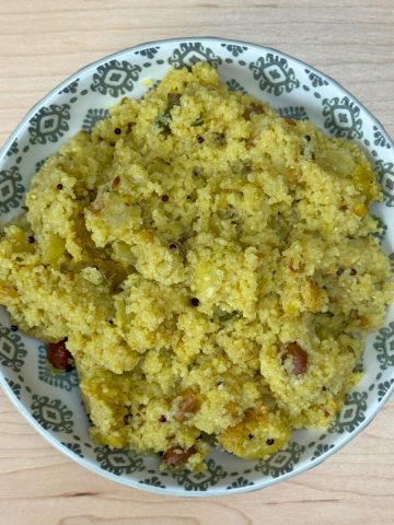 Fluffy South Indian upma served in a bowl, made with semolina (rava), vegetables, and aromatic spices, ready to eat on a wooden table.