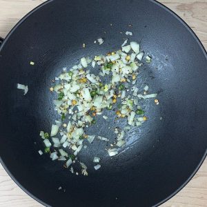 Chopped onions added to the pan after green chilies