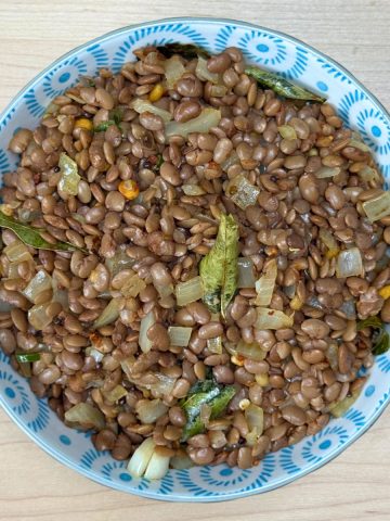 Homemade tempered horsegram snack served in a rustic bowl, featuring protein-rich ulavalu with aromatic Indian spices.