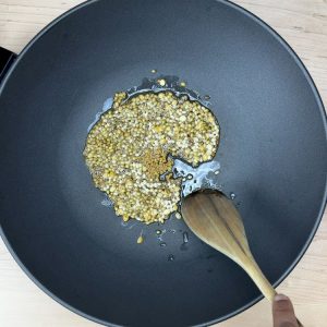 Whole spices sizzling in oil for the tempering of carrot chutney