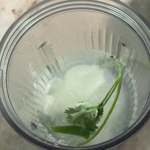 Adding ½ cup of plain yogurt to the blender with spices and water, a key step for creamy, homemade buttermilk.