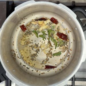 Adding fresh curry leaves to the tempering spices