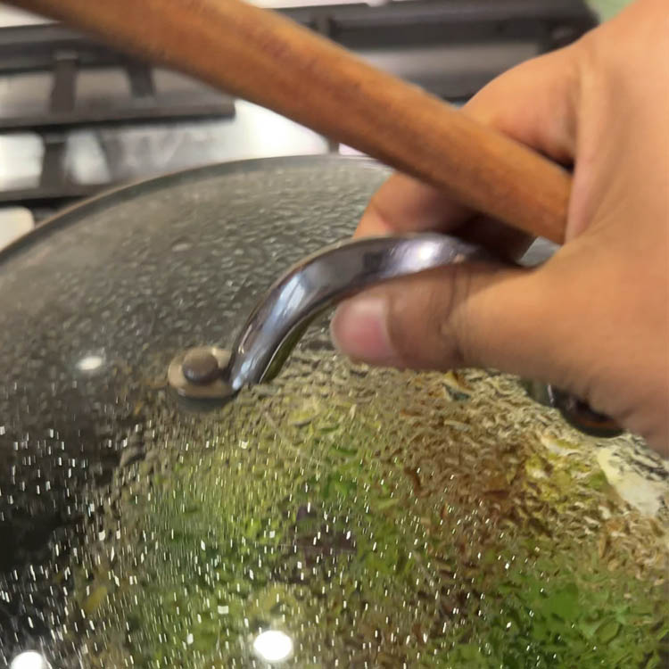 Covered pan cooking broccoli and eggplant mixture for traditional Indian chutney