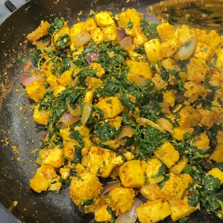 The methi and paneer being thoroughly mixed in the pan, creating a fragrant and well-combined Methi Paneer Stir Fry.