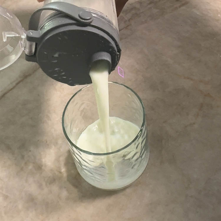 Pouring freshly blended homemade buttermilk into a glass, showcasing its light and refreshing texture, perfect for cooling down.