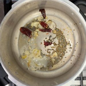 Tempering mustard and cumin seeds in ghee until they splutter