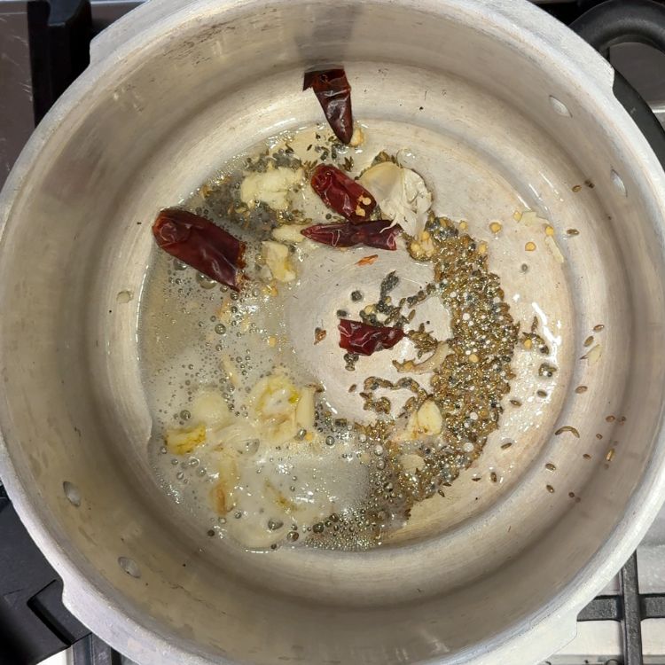 Tempering mustard and cumin seeds in ghee until they splutter