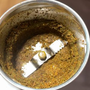 Freshly ground spice mix for Ulavacharu Rasam with black pepper, cumin, and coriander in a blender