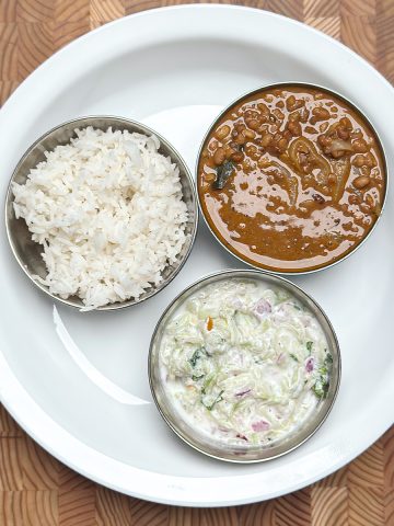horse gram curry with bottle gourd raita & rice in mini bowls on a plate