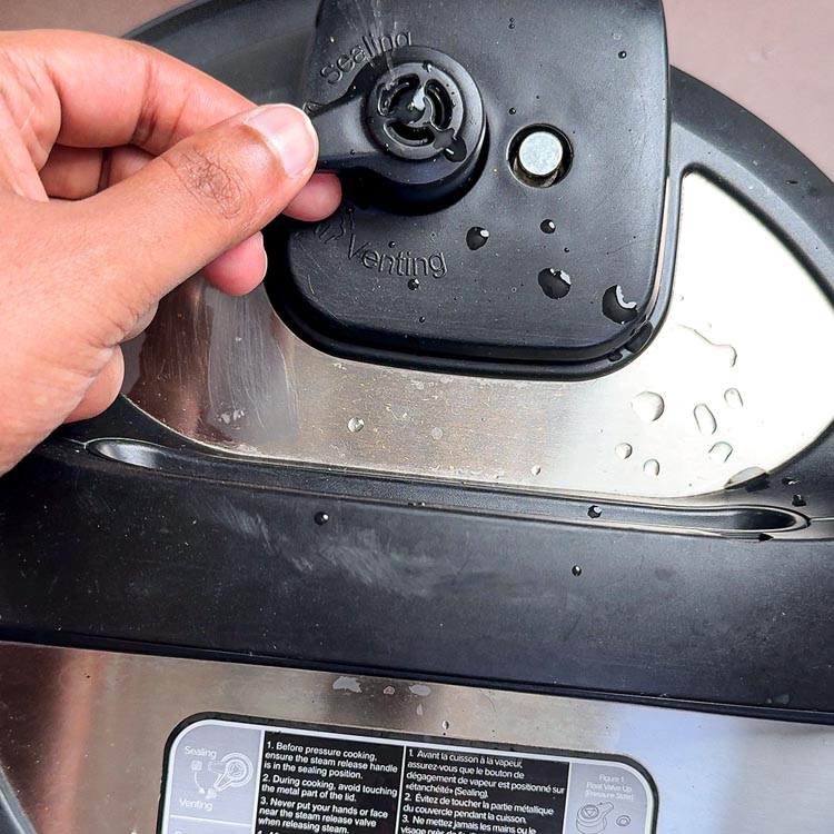 Hand turning Instant Pot valve to venting position after cooking