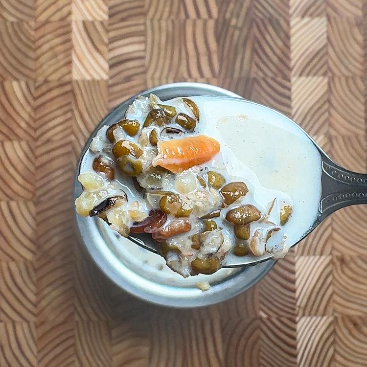 Creamy moong dal payasam in a silver spoon showing smooth texture