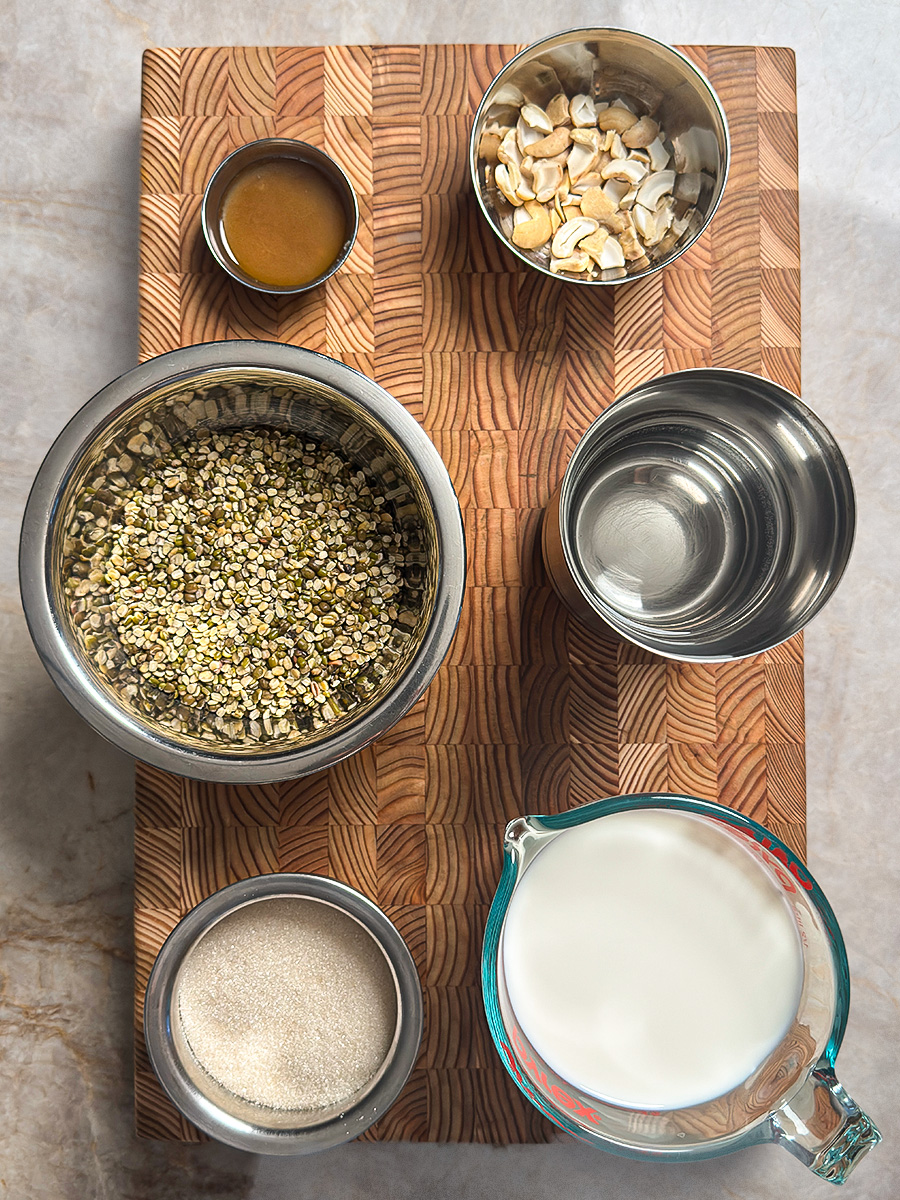 Split green moong dal, cashews, milk, sugar and ghee arranged on counter
