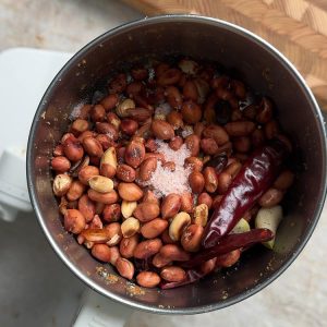 Cooled roasted peanuts, chilies and garlic ready to grind in food processor