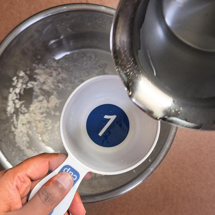 Adding 2 cups of water to rinsed rice in pressure cooker