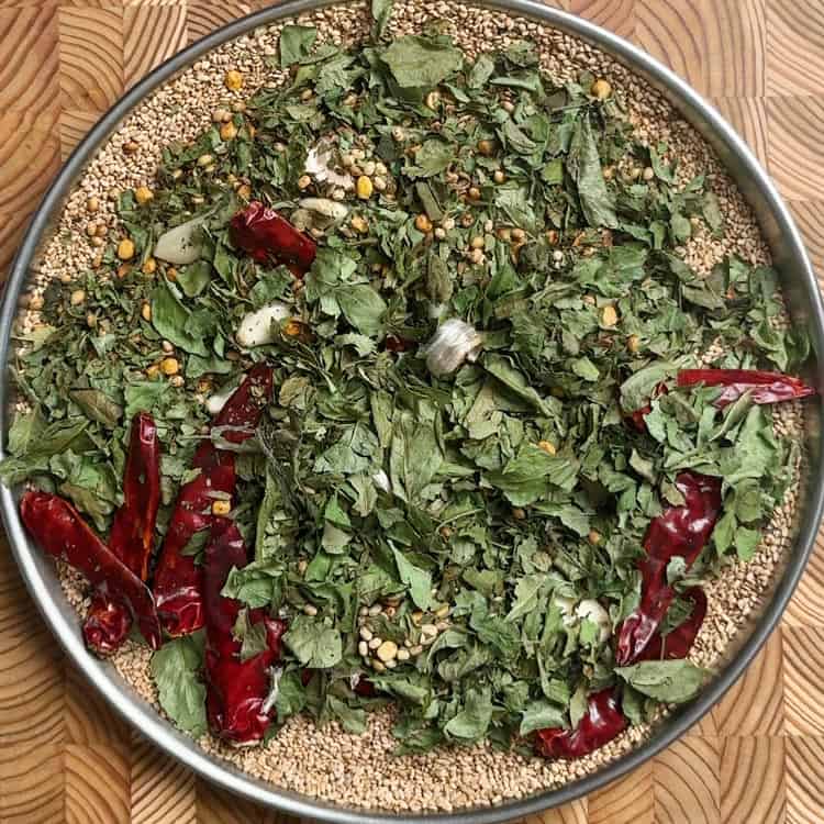 All roasted ingredients spread on steel plate cooling before grinding