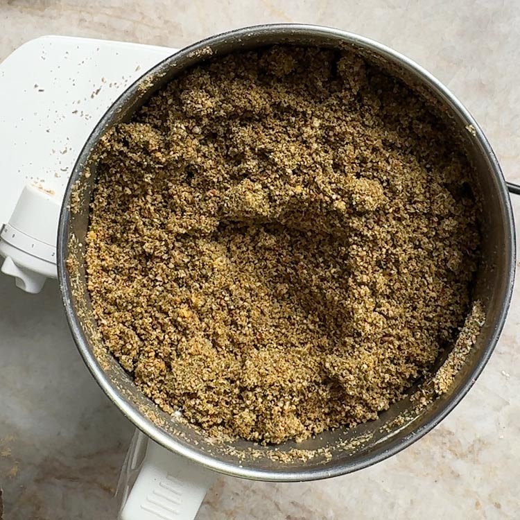 Freshly ground sesame curry leaves powder showing coarse texture and reddish-brown color