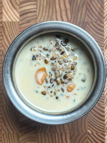 Traditional moong dal payasam served in ceramic bowl on wooden table