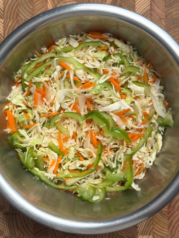Finished cabbage carrot green pepper salad base with crisp white cabbage, orange carrots, and green peppers mixed together