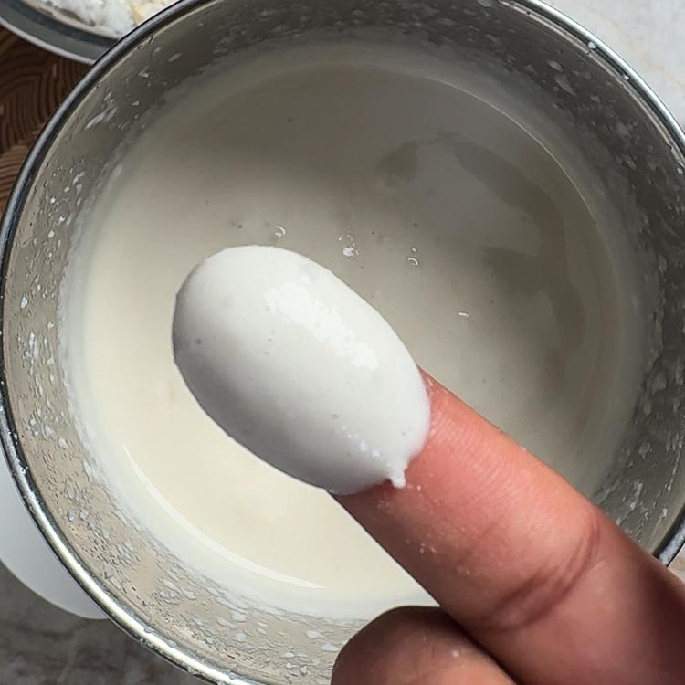 Testing dosa batter consistency with finger to ensure proper texture for fermentation