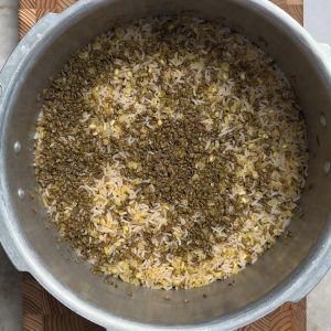 Fully cooked rice and moong dal mixture with fluffy texture visible in pressure cooker