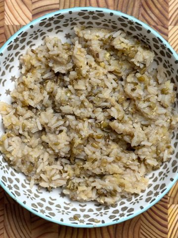 Fluffy cooked high-protein white rice with visible moong dal pieces served in patterned blue bowl