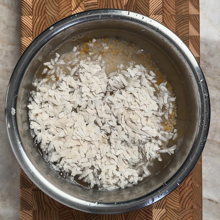 Adding poha (flattened rice) to soaked dosa batter ingredients without rinsing separately