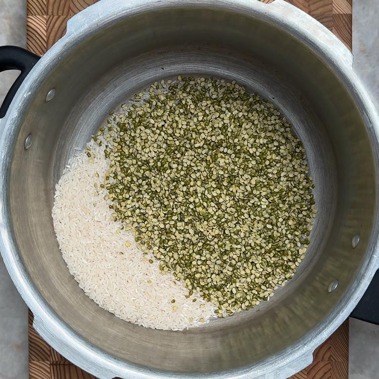 Uncooked white rice and green split moong dal mixed together in stainless steel pressure cooker