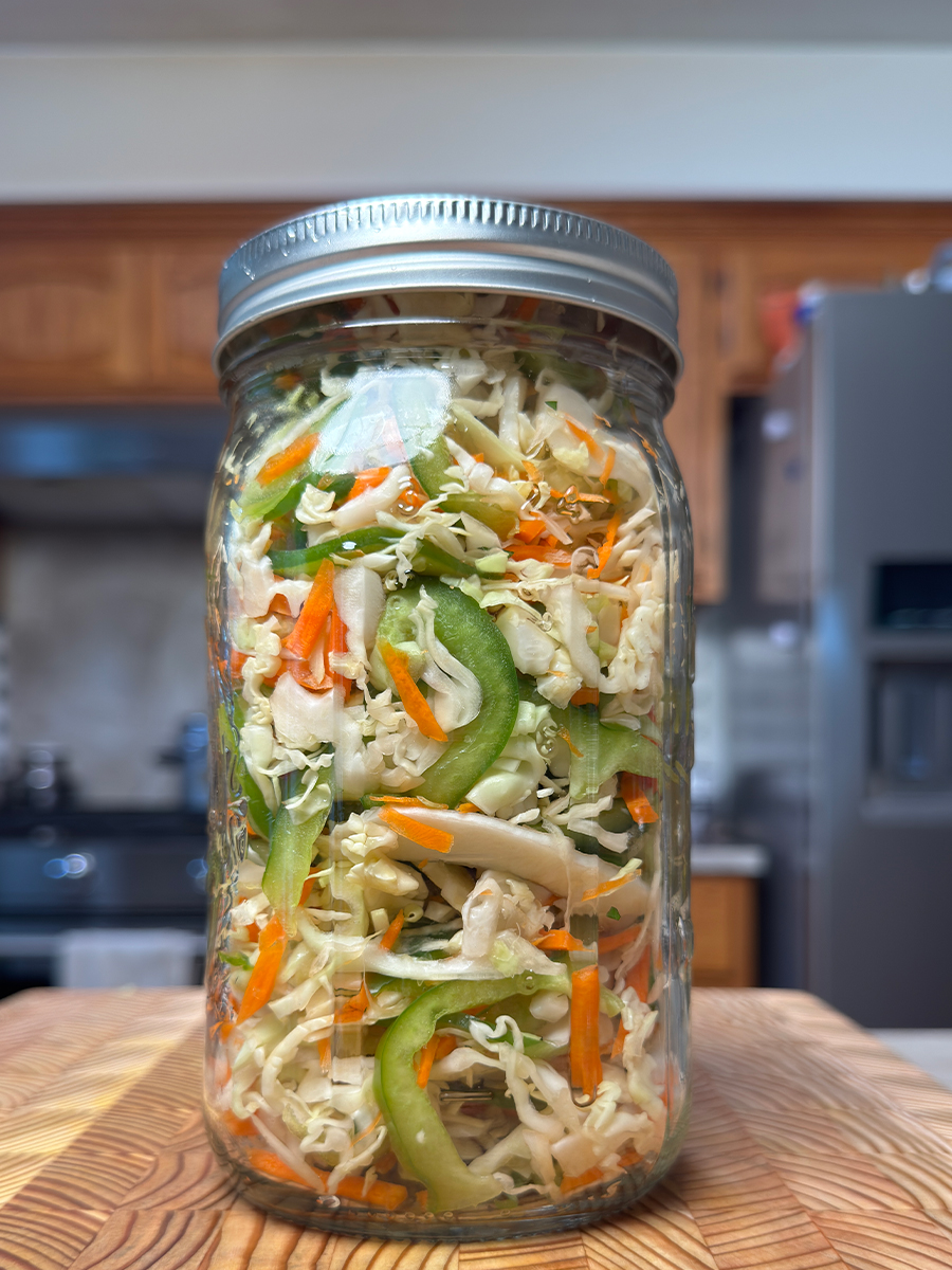 cabbage carrot green pepper salad in an airtight container on the table ready to be stored in the fridge for 5 days