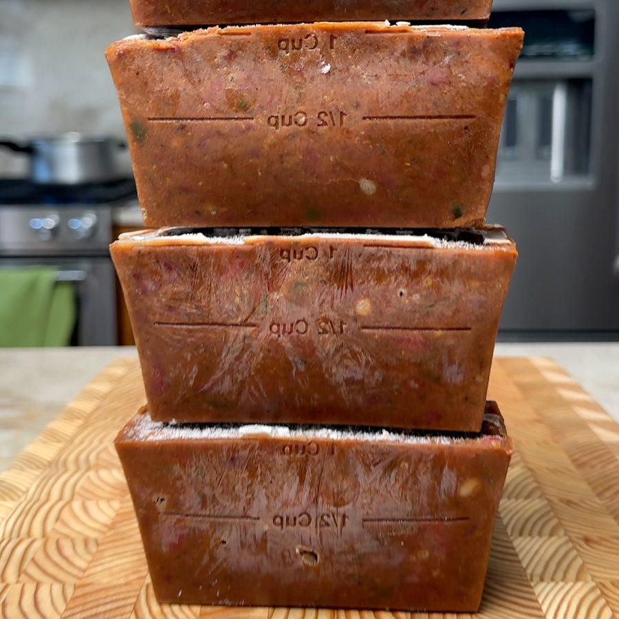 Four frozen brown curry blocks stacked vertically with measurement markings visible