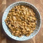 Black eyed peas coconut curry, creamy and golden, garnished with fresh green coriander leaves in a serving bowl