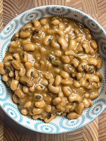 Black eyed peas coconut curry, creamy and golden, garnished with fresh green coriander leaves in a serving bowl