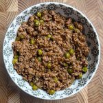 Lamb keema matar served in white decorative bowl showing tender meat and green peas