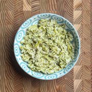 Easy broccoli rice with bone broth served in a blue and white patterned bowl on wooden cutting board