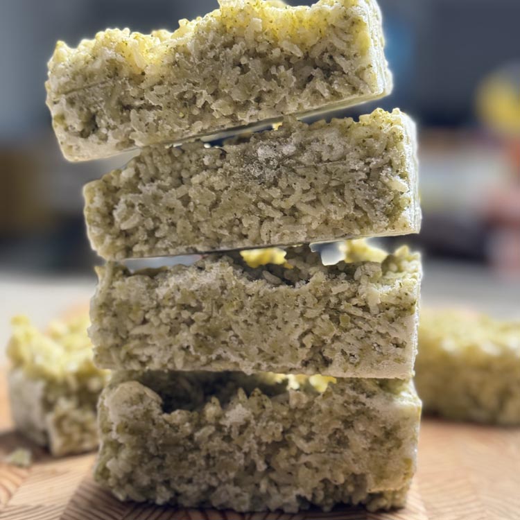 Stack of five frozen broccoli rice with bone broth cubes showing meal prep portions ready for freezer storage