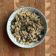 Cooked moringa leaves protein boosted rice with green leaves distributed throughout white rice grains